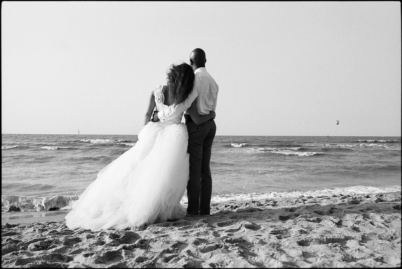 Day After à la plage De Haan Le Coq littoral belge portrait mariés de dos en noir et blanc photographe mariage Nord
