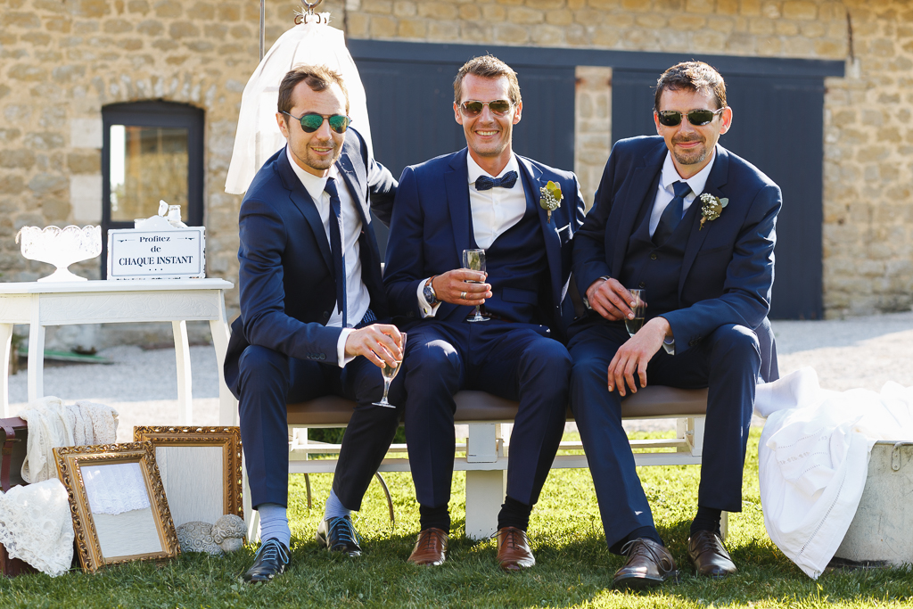 marié et deux invités tous en costume bleu assis sur banc vin d'honneur