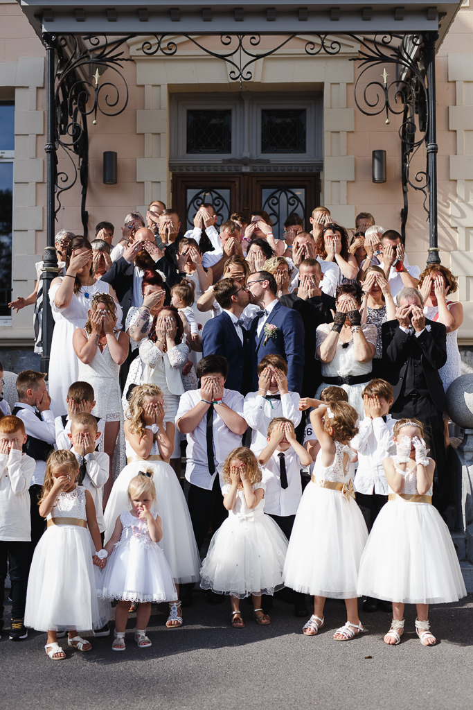 bisou mariés au milieu de tous les invités se cachant les yeux photographe mariage Fourmies Hauts-de-France