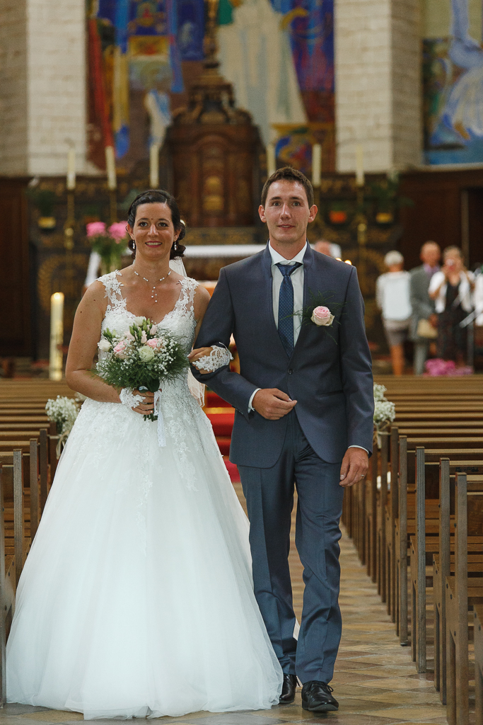 couple fraîchement marié traverse nef église abbatiale Notre-Dame de Licques reportage mariage Hauts-de-France Trois Pays