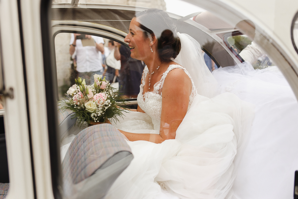 mariée avec bouquet de roses dans 2CV photographe mariage professionnel Fred Laurent Lille Côte d'Opale Hauts de France