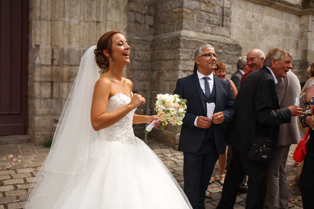 rire de la mariée après cérémonie religieuse Carvin reportage photo mariage Nord Pas de Calais Hauts de France