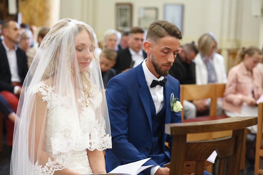 mariée avec voile yeux baissés et mari église Lys-lez-Lannoy photographe mariage cérémonie religieuse