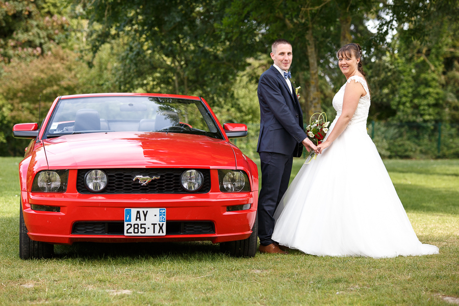 portrait couple mariage en mustang rouge séance couple photographe mariage à la campagne proche Béthune La Bassée