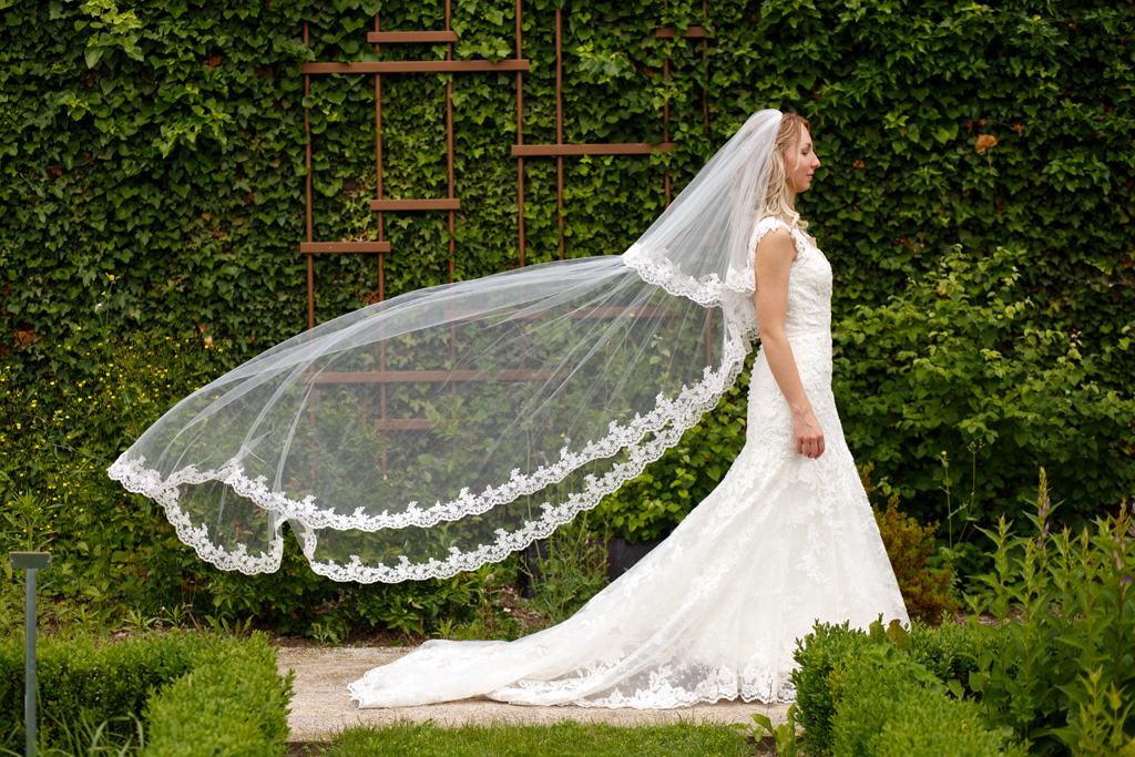 Voile de la mariée dans le vente pendant la séance photo après mariage dans le parc de Robersart à Wambrechies. Photographe mariage Wambrechies. After Day et engagement des mariés.