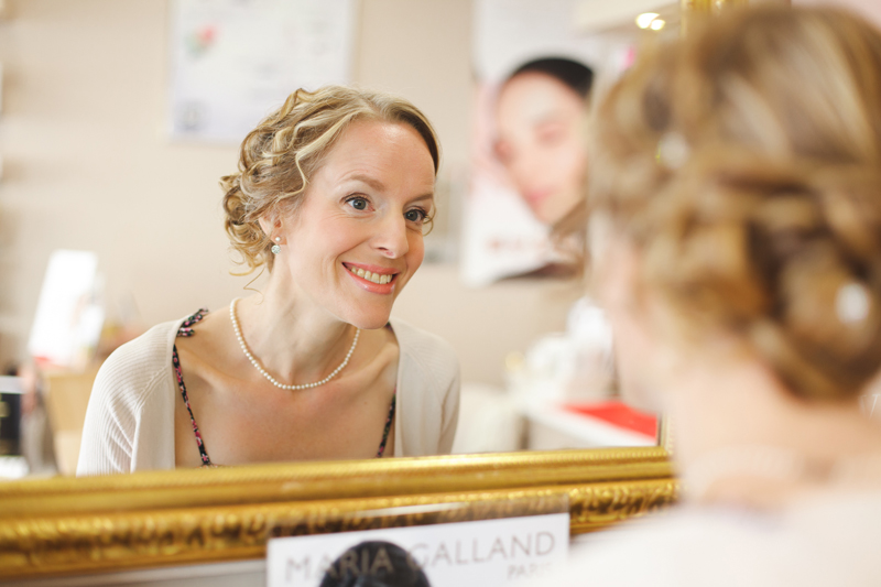 préparatif de la mariée sourire devant le miroir - photographe mariage Lille Nord Hauts de France