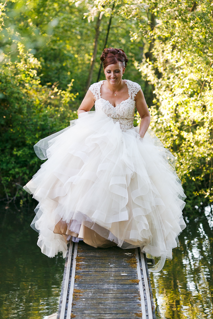 Mariage en plein air au bord de l'eau - la mariée sur la berge de l'étang - Reportage photo des mariés dans la nature