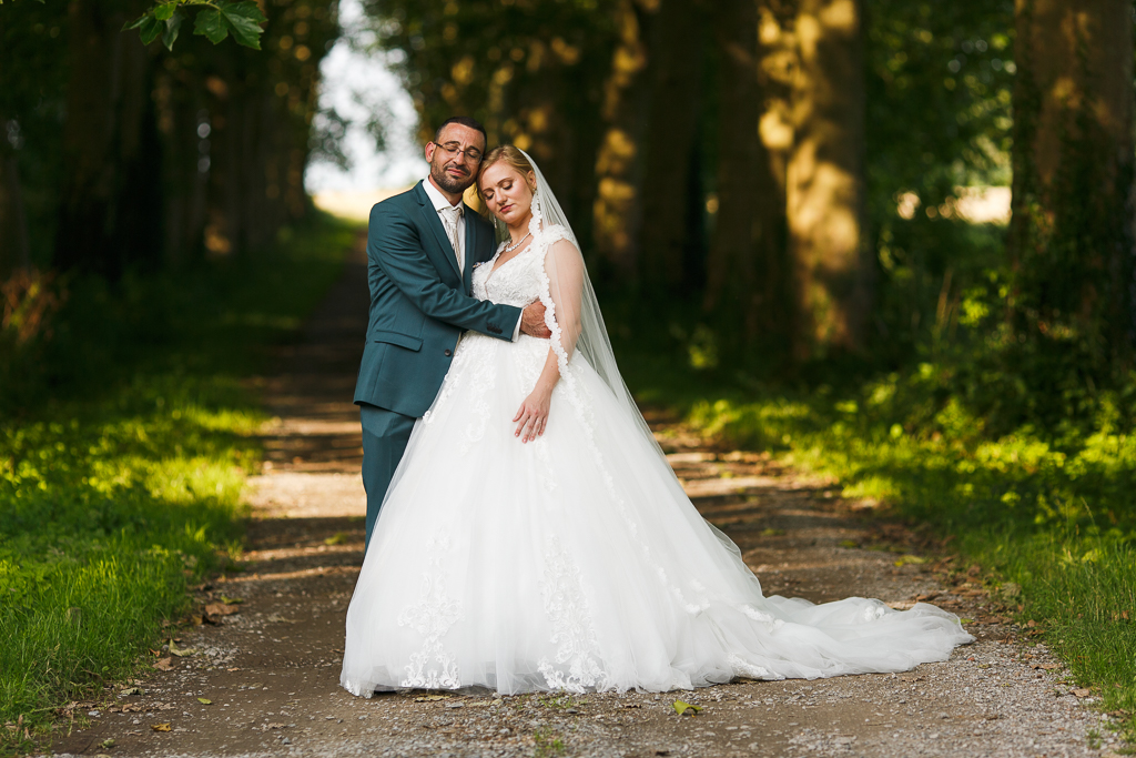 Photographe mariage portrait des mariés allée d'arbres du château