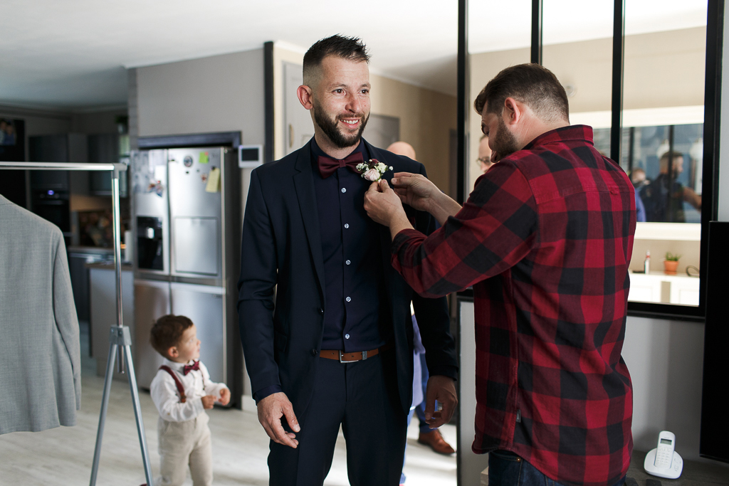 Le marié aide un témoin pendant les préparatifs avant la cérémonie de mariage. Reportage photo des préparatifs du marié.