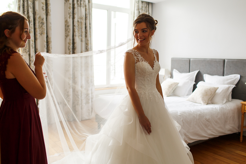 Habillage de la mariée en compagnie de la famille proche dans la chambre du château. 