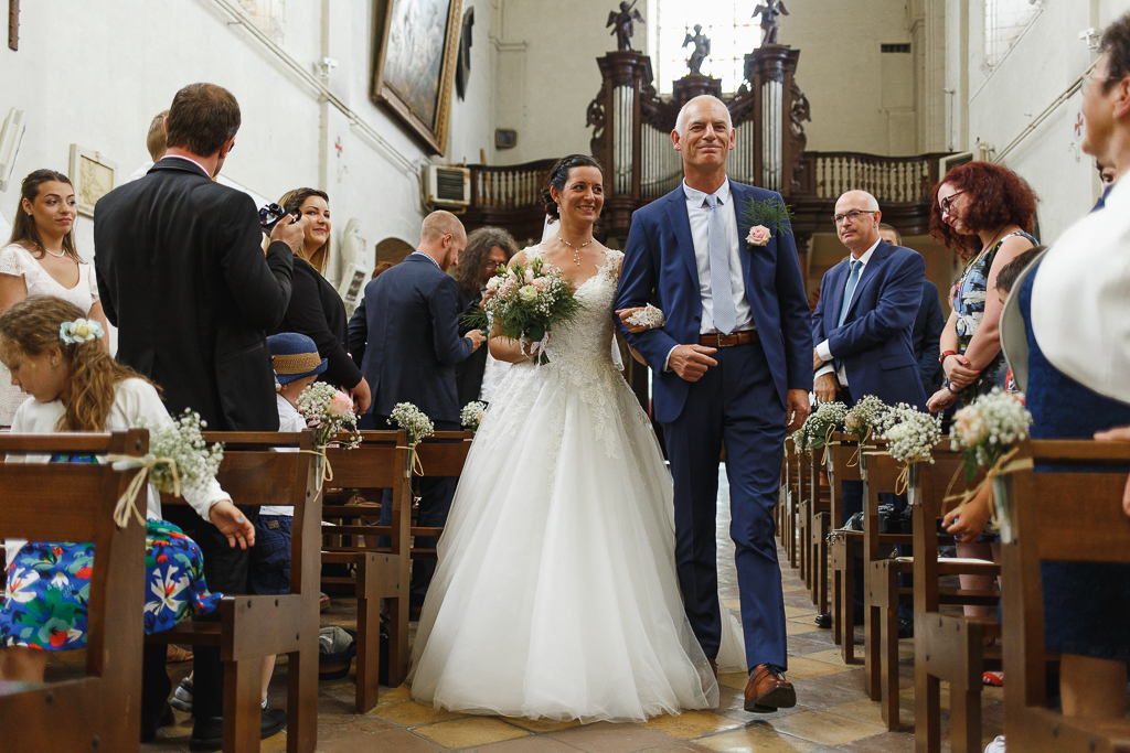 Entrée de la mariée dans l'église au bras de son papa. Cérémonial religieux protocole des mariés photo de mariage Nord. 