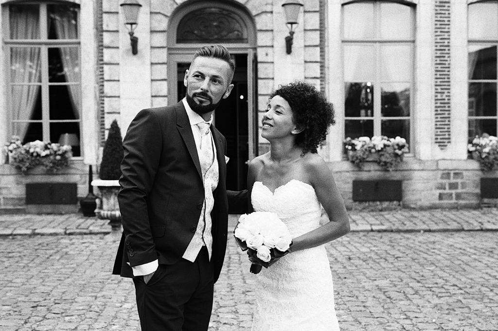 Photo du couple devant le domaine de réception. Photographe mariage argentique Nord.