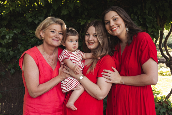 Séance photo famille à Wambrechies dans un jardin fleuri. Portrait de femmes et enfant en rouge. Photographe professionnel Wambrechies.