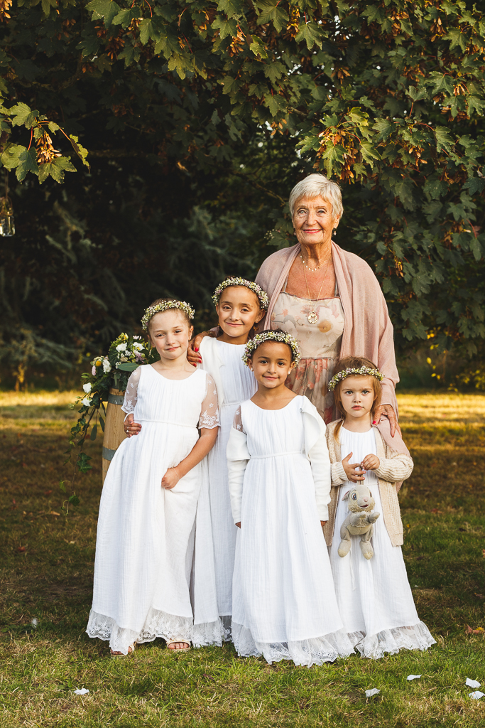 Portrait d'une grand mère et de ses petits enfants habillés tout de blanc et couronnes de fleurs. Photographe événements mariages Nord Fred LAURENT;