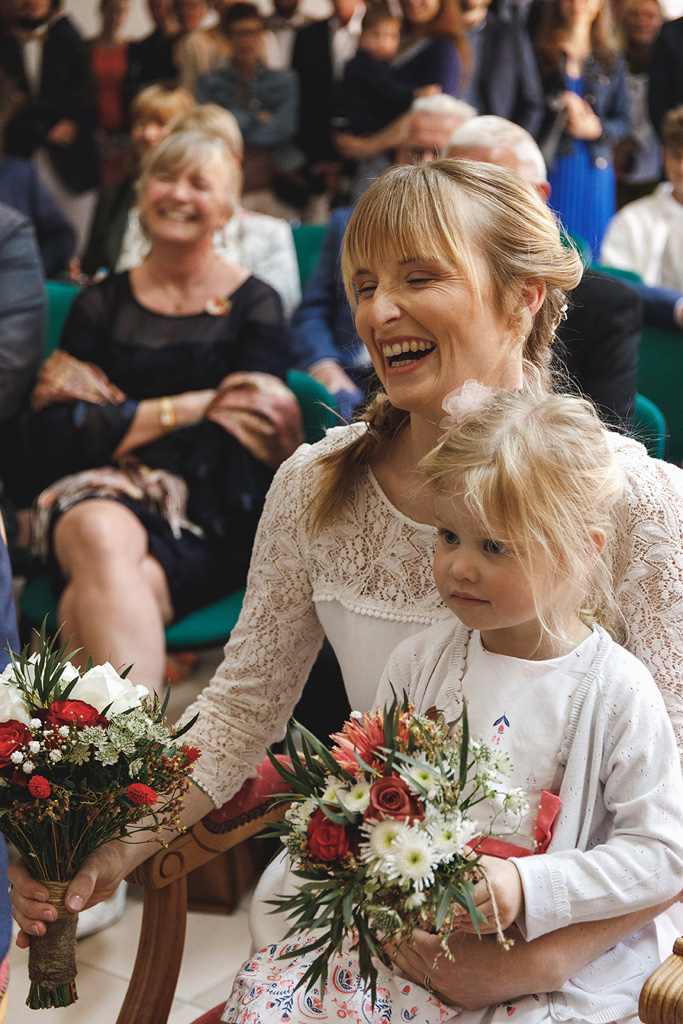 Photo de la mariée en éclat de rire pendant la cérémonie civile. Photos de mariage prises sur le vif à Lille.