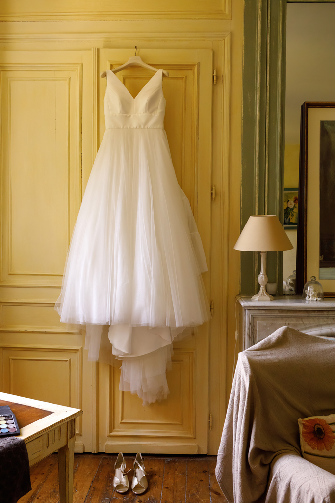 La robe de mariée suspendue à la fenêtre du château. Préparatifs de la mariée au Château La Chataigneraie. reportage photo mariage coup de cœur à Wambrechies. 