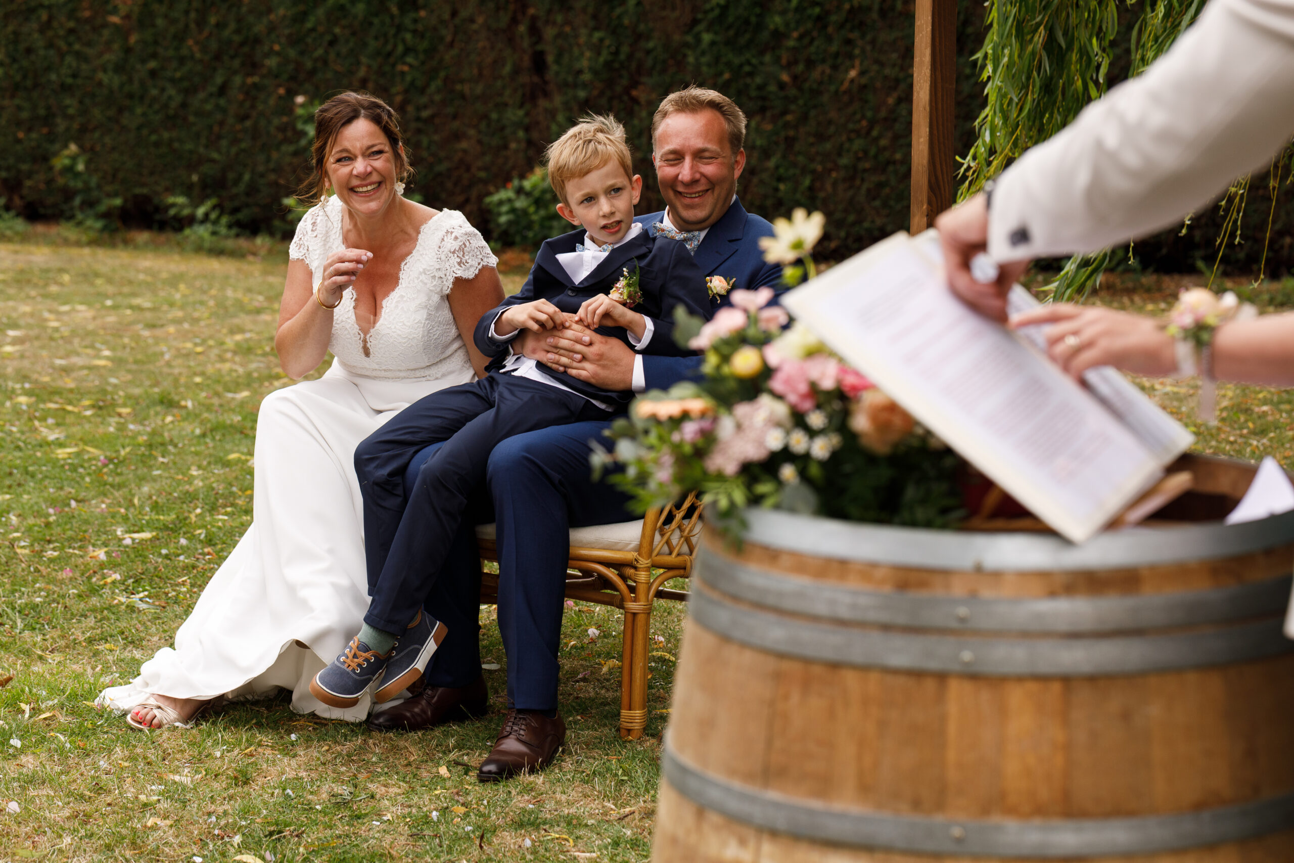 couple marié et enfant pendant la cérémonie laïque dans un jardin