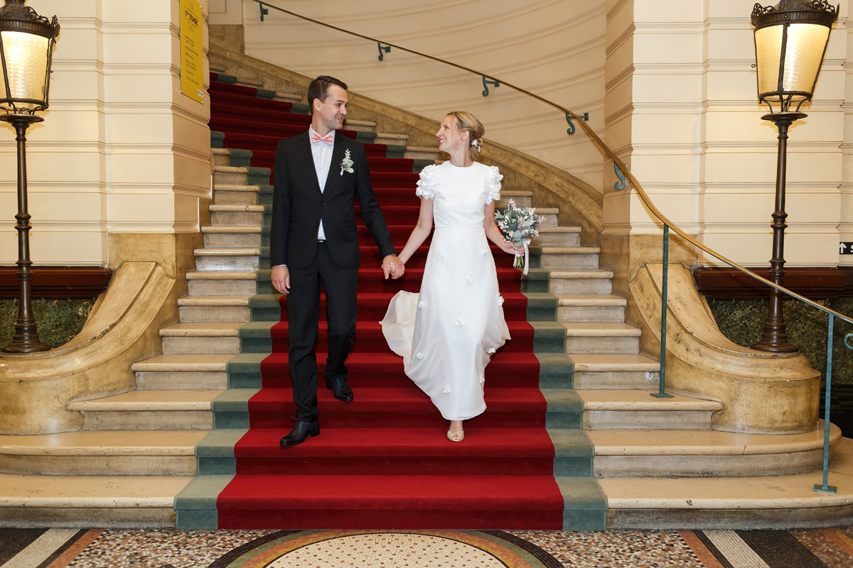 Photographe mariage Tourcoing mairie. Les mariés descendent les escaliers dans le hall de la mairie.